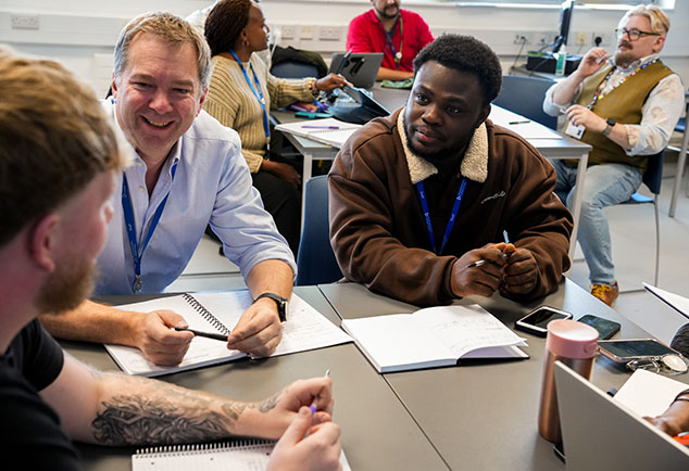 College staff members sitting around tables talking