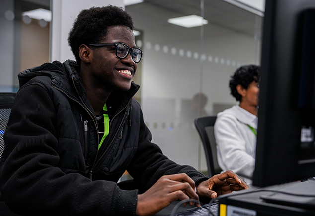 Student smiling at computer
