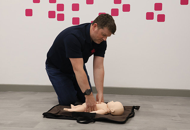 Man performing CPR on Infant Manikins