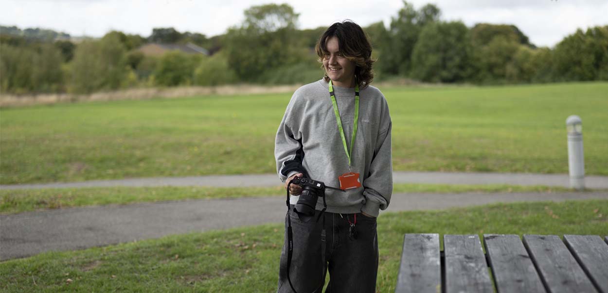 Person standing outside holding camera