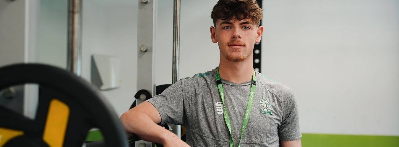 Student standing in gym looking at camera