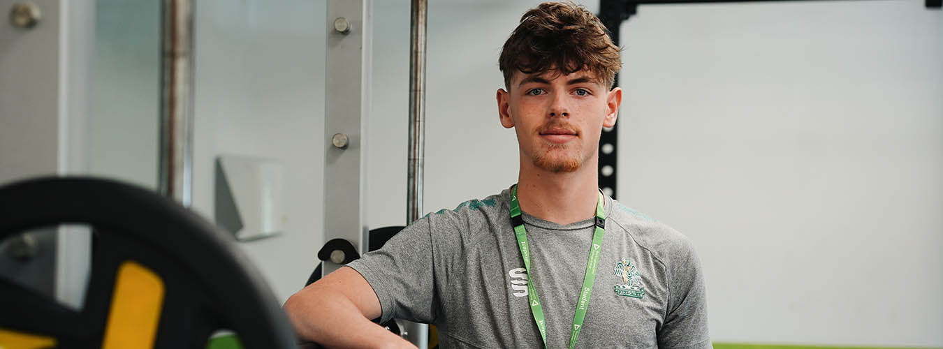 Student standing next to gym equipment