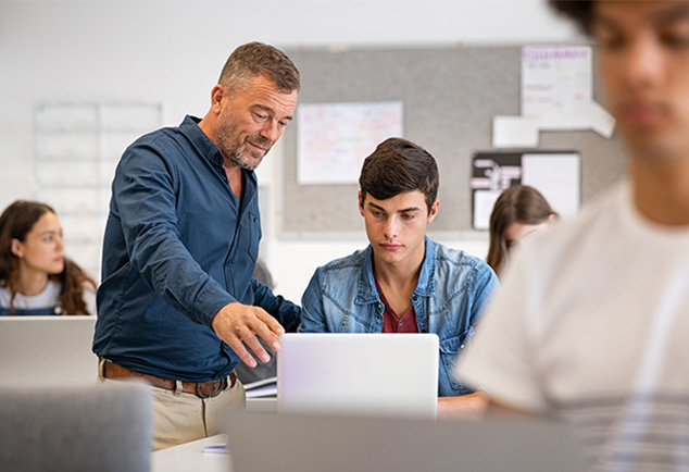 Teacher helping student in classroom