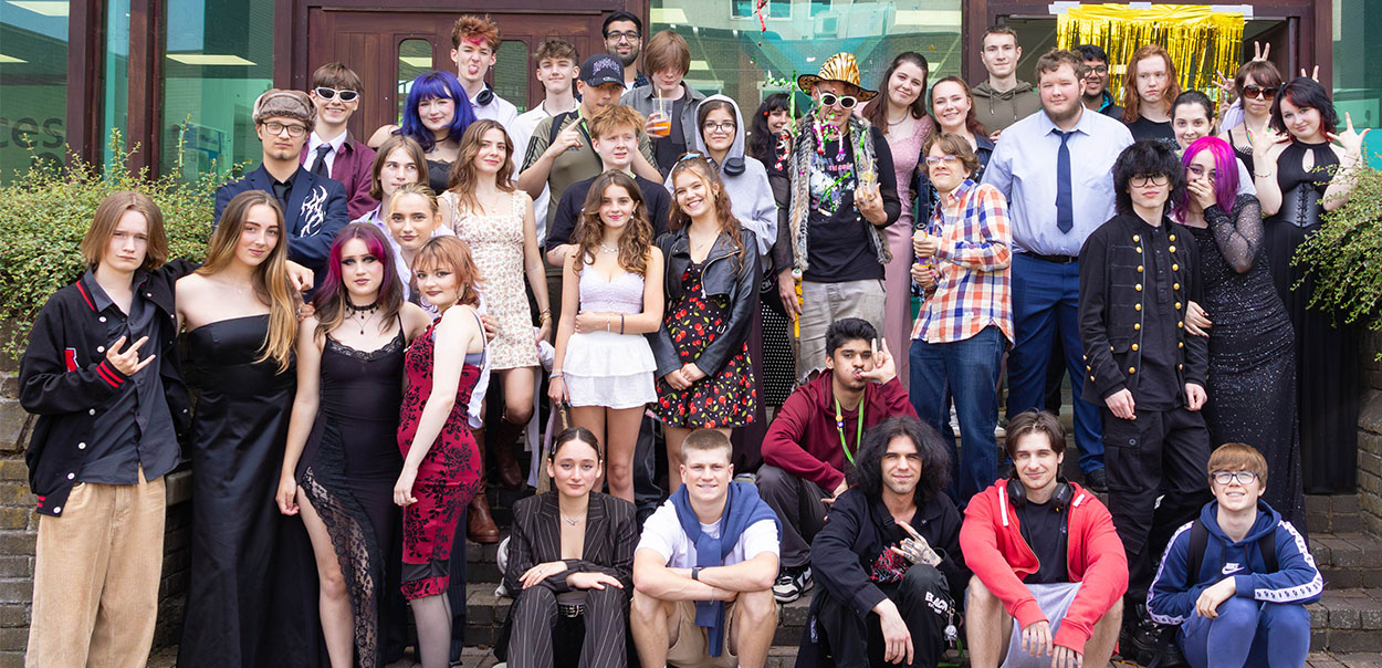 Large group of students standing together for photo outside wearing prom outfits